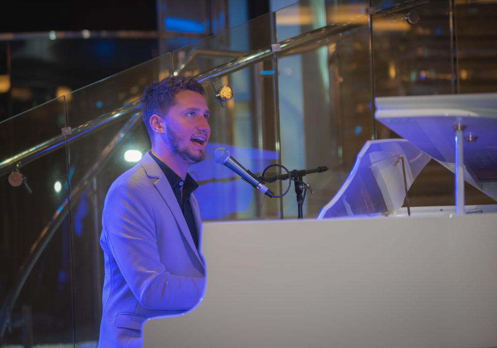 Pianist Singer performin on White Grand Piano